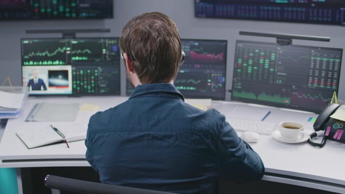 男性交易员在电脑上处理交易市场图表
