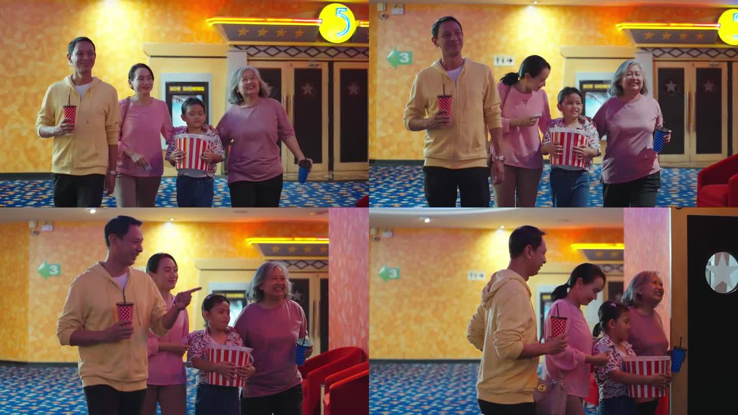 快乐的亚洲家庭准备一起去电影院看电影。欢快的亚洲家庭拿着碳酸饮料和爆米花去电影院看电影。家庭活动