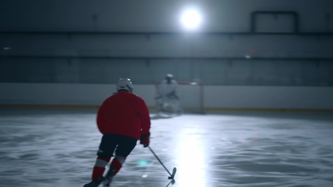 专家曲棍球运动员在红色球衣展示了令人印象深刻的技术和速度在冰上，躲避障碍和得分