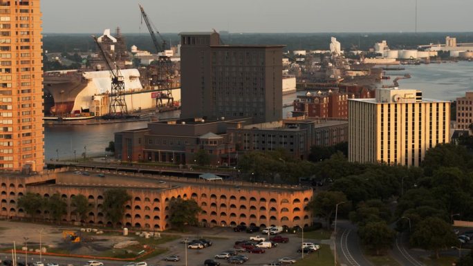 夕阳工业区与停车场的河边朴茨茅斯，弗吉尼亚州。海军造船厂与军舰正在建设在远处。航拍镜头与平移相机运动