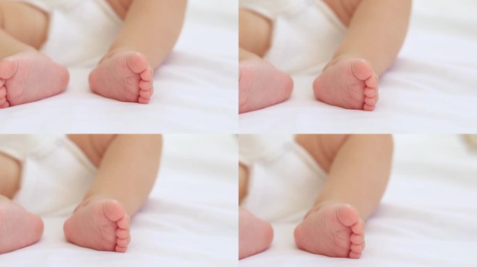 宝宝的小脚在白色的床上，一个文字的地方，一个小婴儿的脚的特写