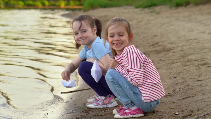 孩子们在夏日公园的河上玩纸船，在夕阳下欢笑