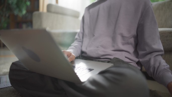 一个男性在家工作的特写，使用笔记本电脑来优化性能和实现目标，创建引人入胜的内容和管理远程家庭工作空间