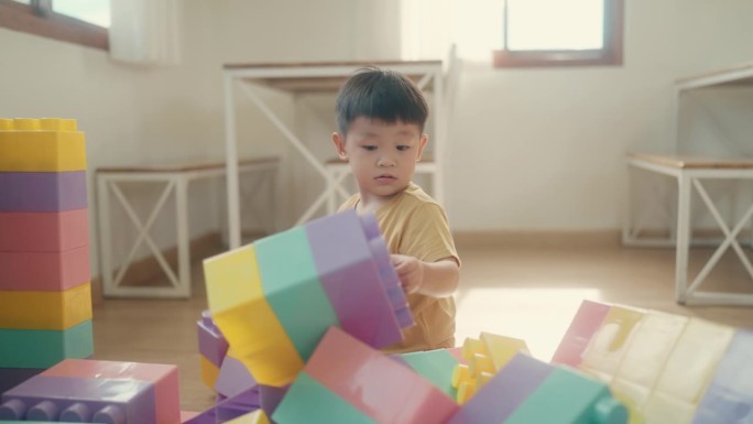 童年的快乐:亚洲幼儿在室内玩积木时拥抱想象力和乐趣。