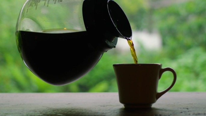 吧台上黑色咖啡壶装满杯子的稳定镜头。