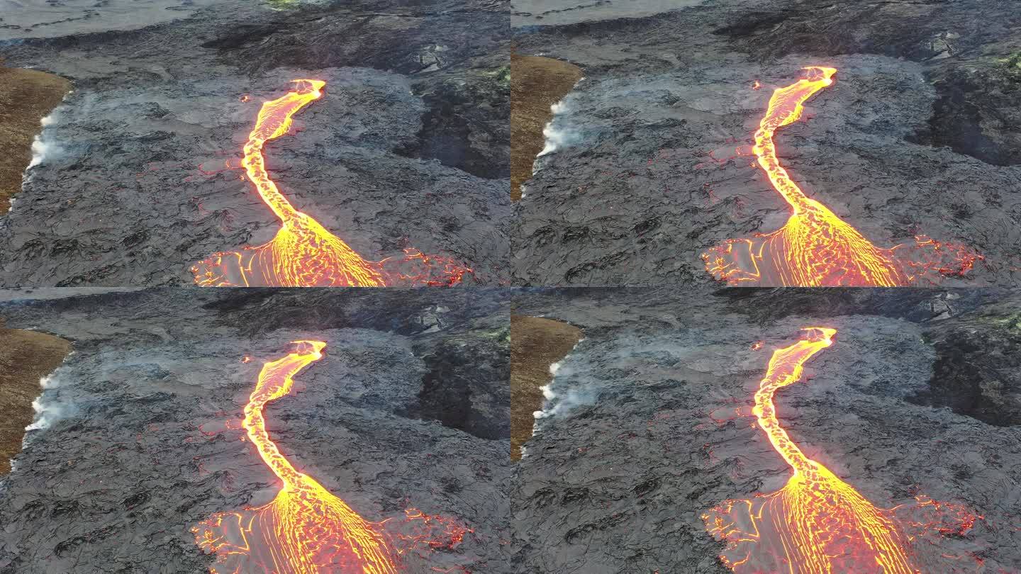 冰岛。火山喷发。大自然的奇迹。炽热的熔岩从地面喷发出来。无人机在活跃的火山口上空飞行。熔岩穿过深色岩