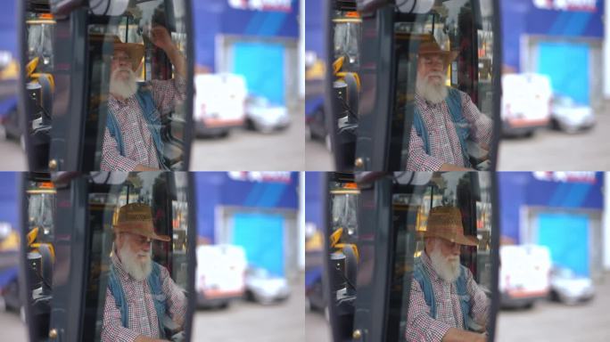 后视镜里，一个戴草帽的白人老头坐在拖拉机车厢里。自信的农民选择收割机在户外购买新车。
