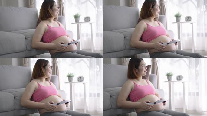 孕妇一边听音乐，一边用耳机触摸宝宝的腹部