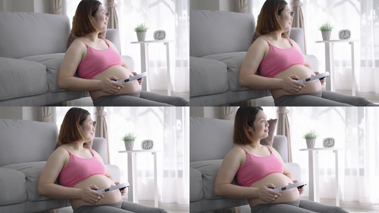 孕妇一边听音乐，一边用耳机触摸宝宝的腹部