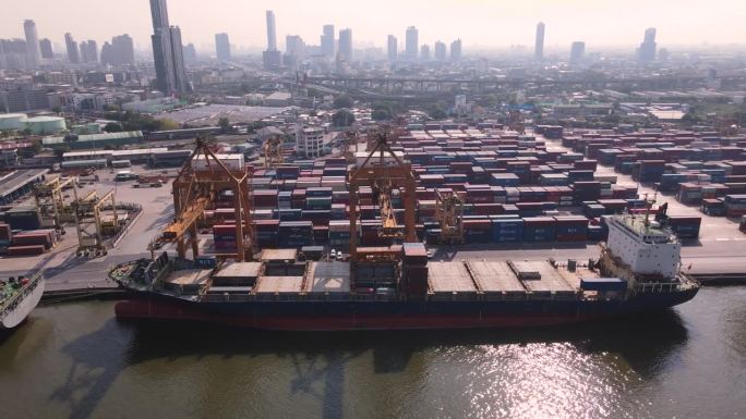 一艘满载货物的集装箱船停靠在港口的船场