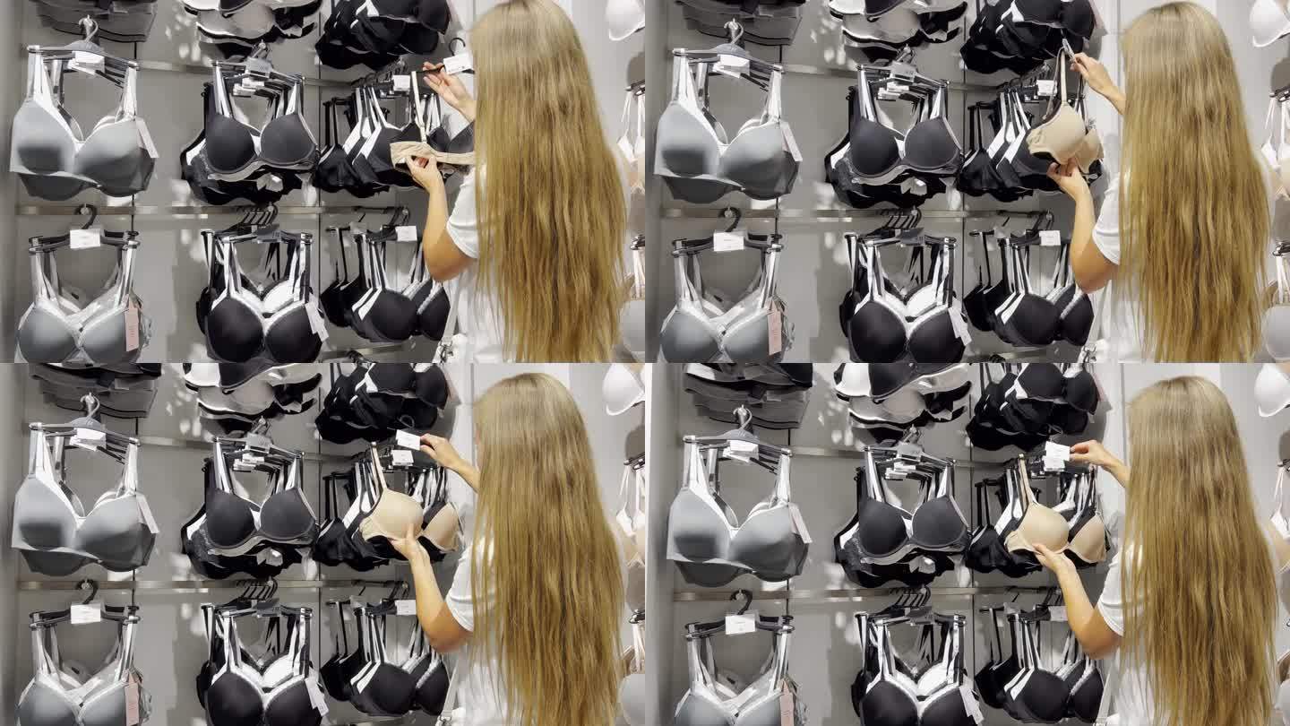 一个金发女人在商店里寻找新内衣，并在看胸罩。内衣店