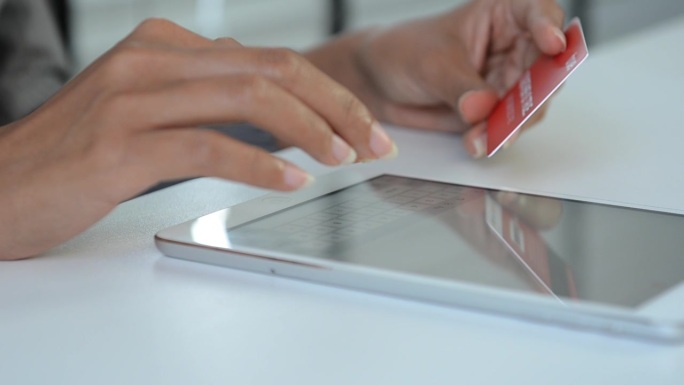 在电子商务应用中，近距离用手在平板电脑上打字确认付款。