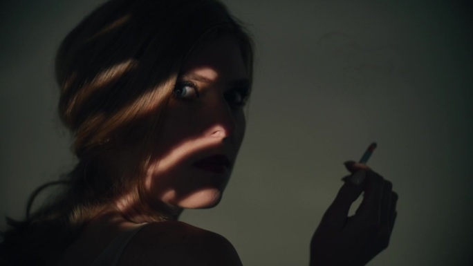 一个优雅的女人在摄影棚里抽烟。