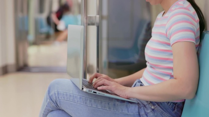 女人在捷运上使用笔记本电脑