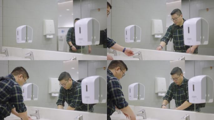 一个高大的亚洲男人在公厕的镜子前洗手