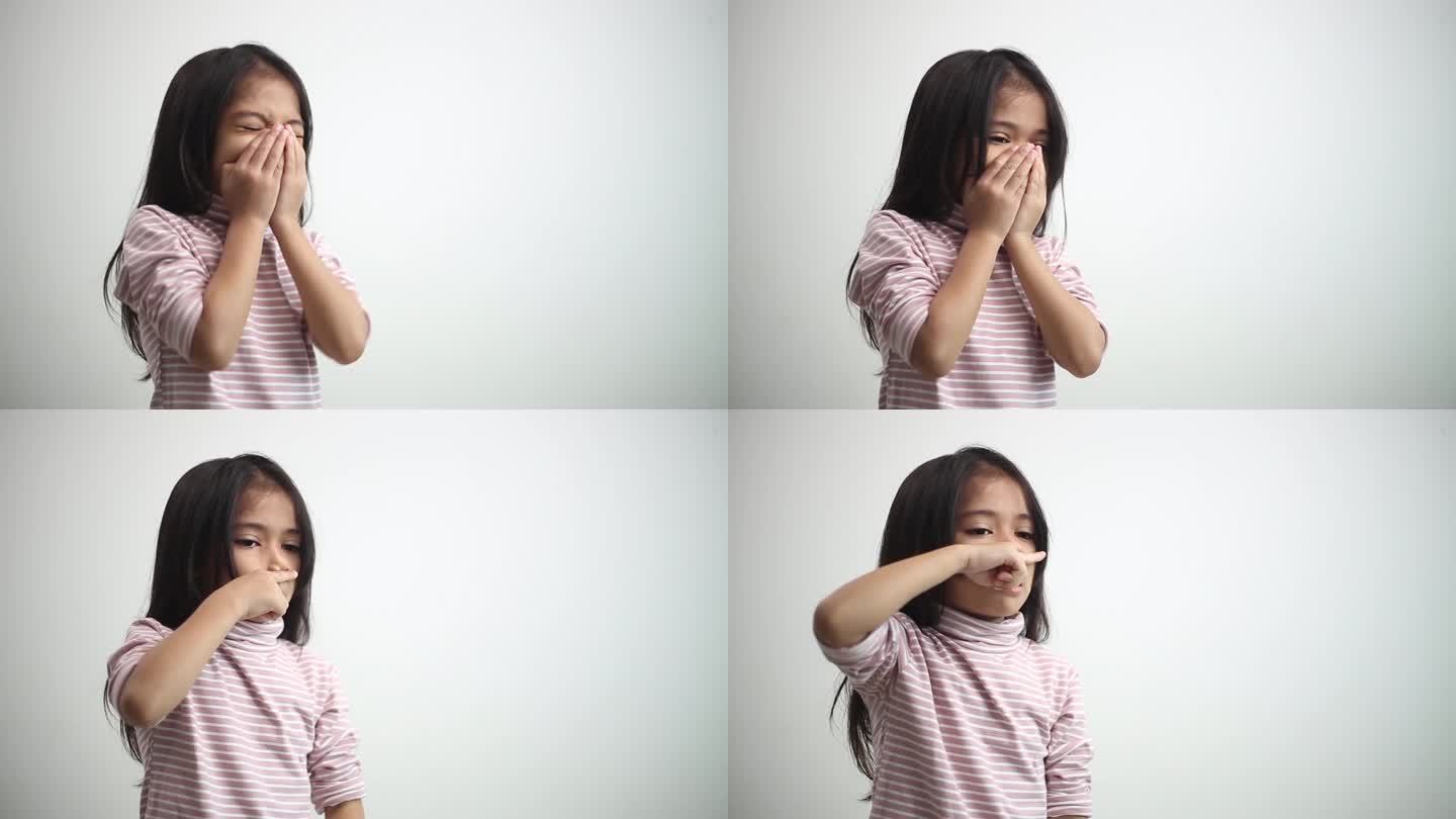 一名亚洲小女孩因身体虚弱或受沙尘天气影响感染病毒和细菌，导致鼻子打喷嚏和感冒咳嗽。在白色背景上。