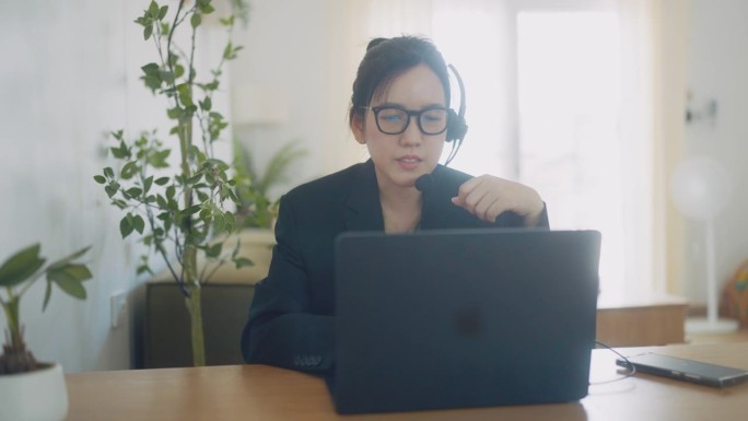 女商人在视频会议上谈论销售报告。亚洲团队使用笔记本电脑和平板电脑在线会议视频通话。在家工作、远程工作