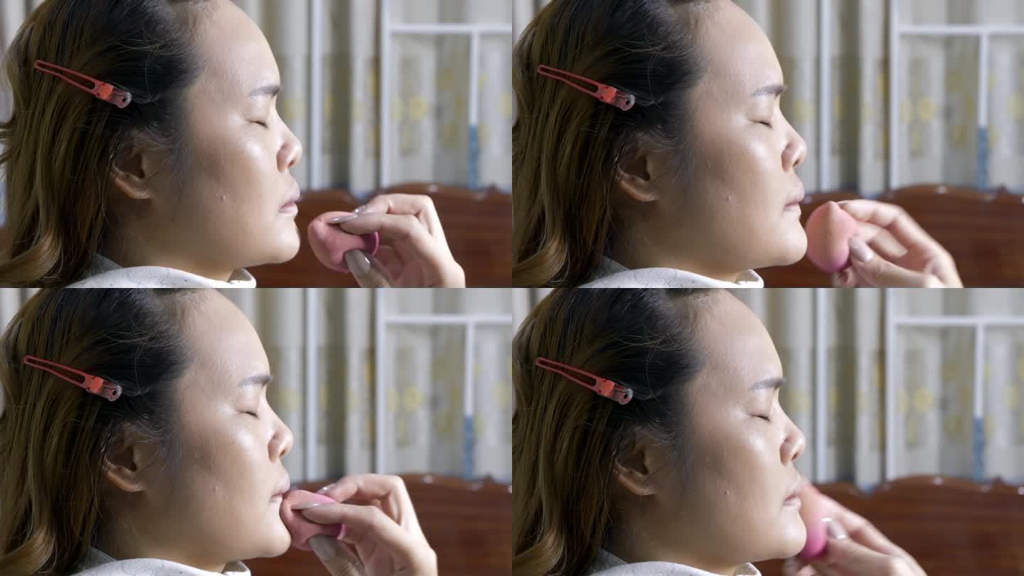 化妆师正在给客户脸上涂粉底。