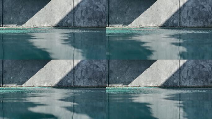 水泥墙上蓝色游泳池的水波，建筑行业