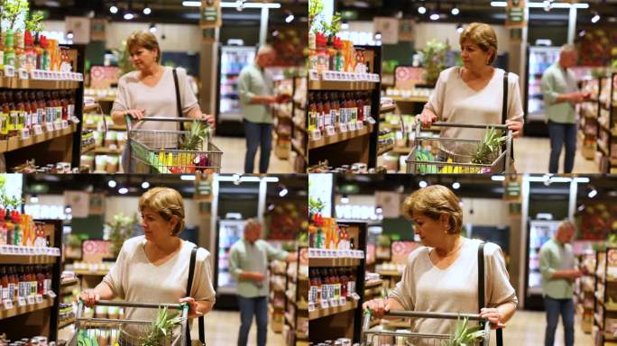 成熟的拉丁美洲妇女在超市购物，一边推着购物车一边看着货架上的产品