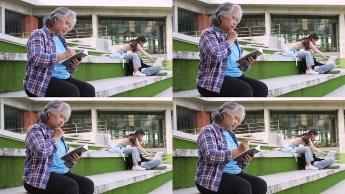 参加完大学课程的成年学生坐在大学大楼前阅读学校书籍，成人教育学习学习快乐亚洲老人退休活动