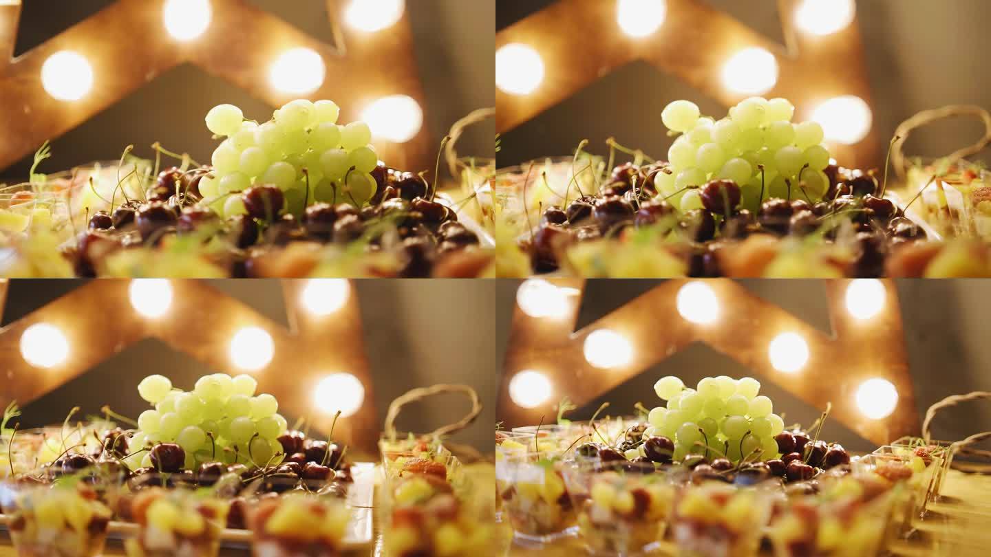 盘子边上放着一根葡萄枝，被美丽的灯光照亮。平滑的相机运动。近距离拍摄浆果