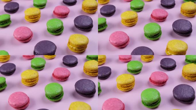 背景的甜马卡龙饼干在不同的颜色在一个粉红色的背景