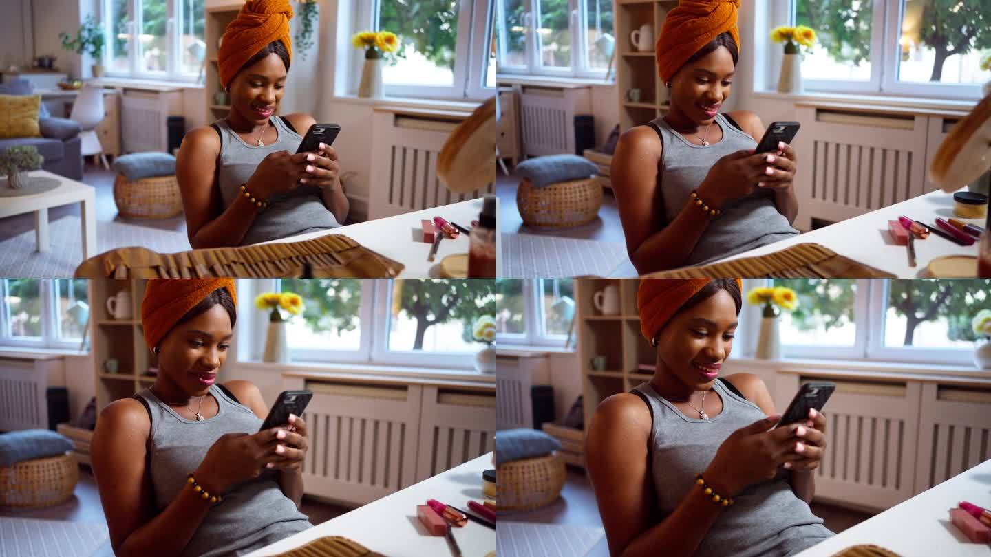 一名黑人妇女在化妆时使用手机