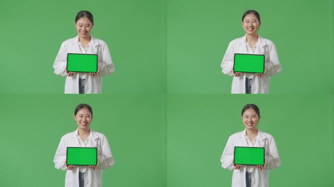 亚洲女医生站在医院绿屏背景上微笑着展示绿屏平板