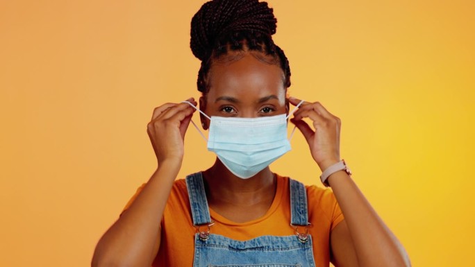 新冠口罩、健康和工作室黑人女性细菌安全保护、新冠病毒合规性或安全政策。肖像，医疗保健或女性，橙色背景