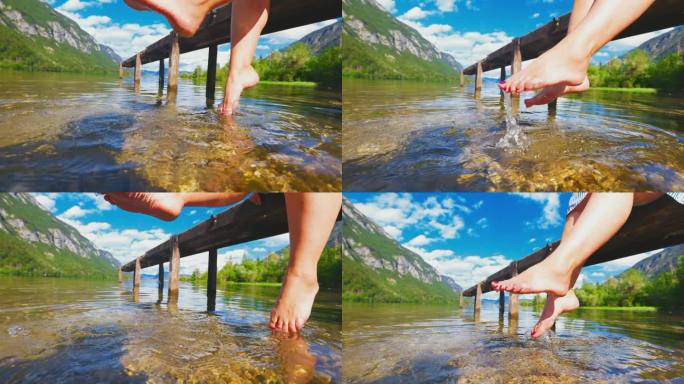 SLO MO女人的腿在湖里玩水。一个坐在码头上的女人的脚晃来晃去，碰到了水。在湖里喝点茶点