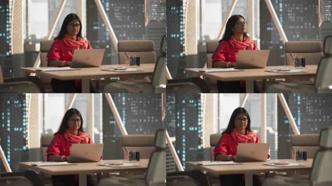 一位印度女商人在一家金融科技创业公司用笔记本电脑工作的赋权肖像。金融分析师对新兴南亚股市进行研究