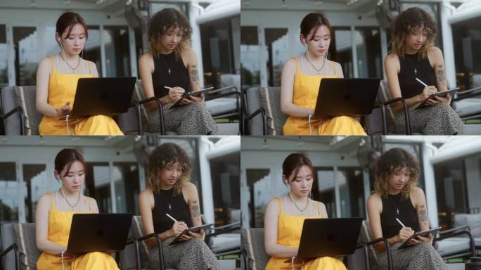 两个亚洲女性朋友在咖啡馆见面时正在工作和使用数字平板电脑。