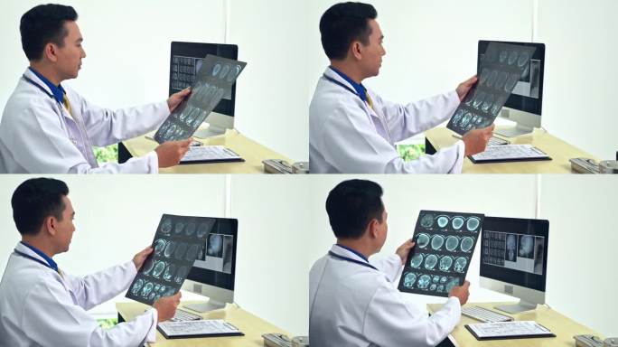 男医生带着听诊器专心地看x光片。