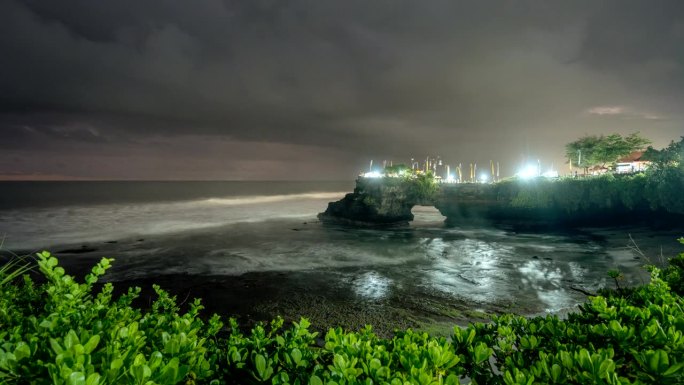 在印度尼西亚巴厘岛的塔纳洛特海滩，人们在印度教仪式上移动的延时日落场景