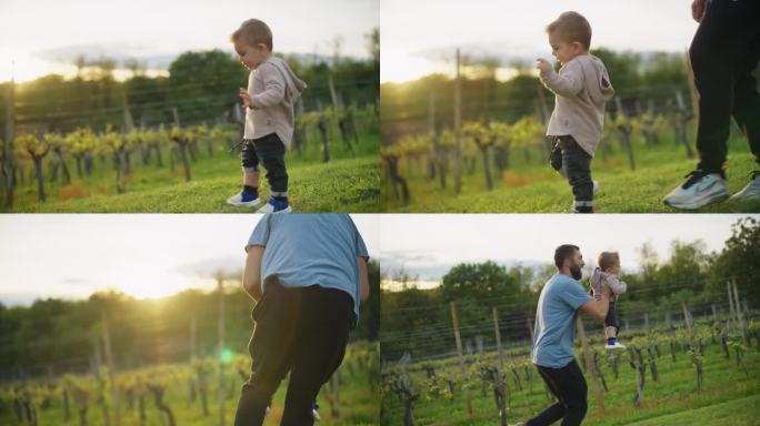 慢镜头男子抱起小男孩，跑上草地。快乐的父亲和儿子玩得开心