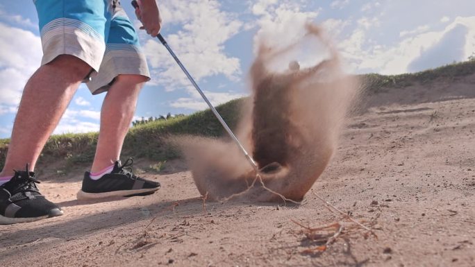 职业高尔夫球手从沙坑里打出高尔夫球