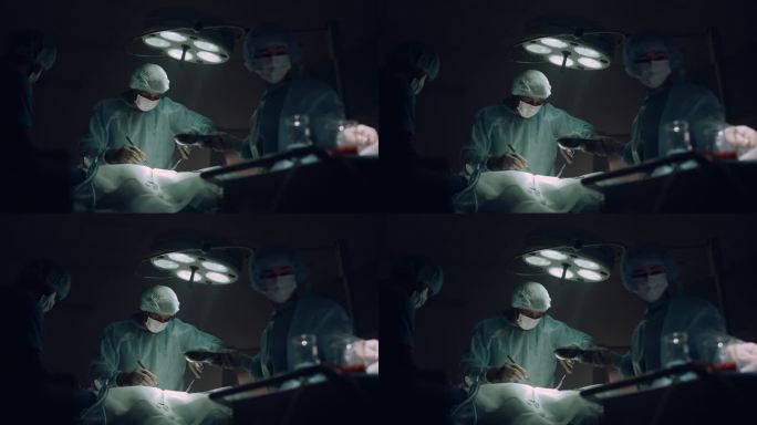 医生团队在黑暗的医院手术室里进行外科手术。