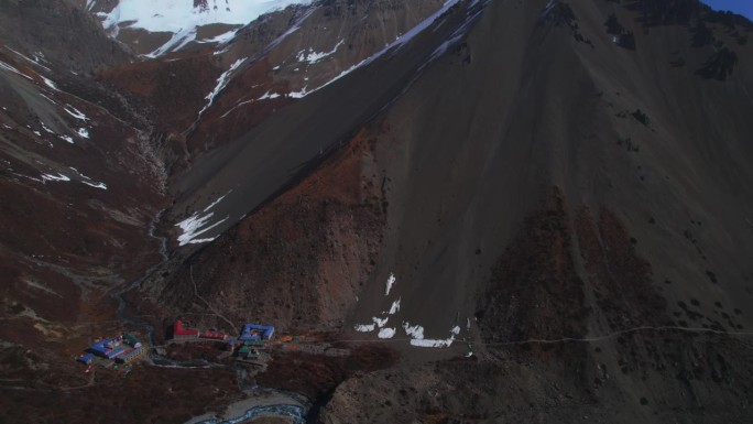 航拍照片显示，在马南区山顶上，Tilicho基地营地和河流和建筑群的小径。喜马拉雅山脉。尼泊尔山脉。