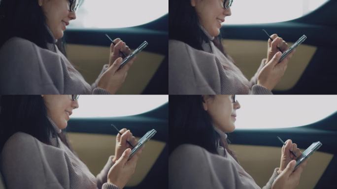 创意女性坐在汽车后座上用智能手机写短信，看着窗外她很开心