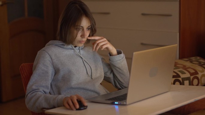 年轻专注的女人在家办公室用笔记本电脑工作。自由职业者，远程工作，在家工作。平面设计师，图像修图师在工