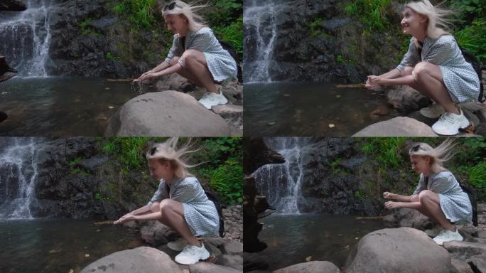 一个女人的特写，她的手正在从瀑布里接水