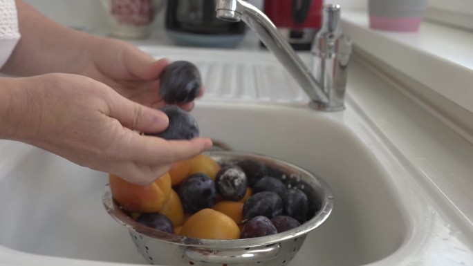 在水槽里用流动的水清洗水果