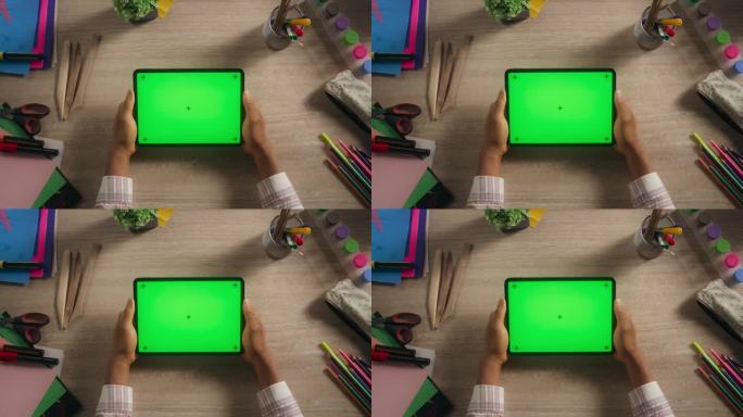 有创意的多种族黑人艺术家拿着绿屏模拟显示器的平板电脑，上面放着艺术用品。视频模板的数字演示，设计内容