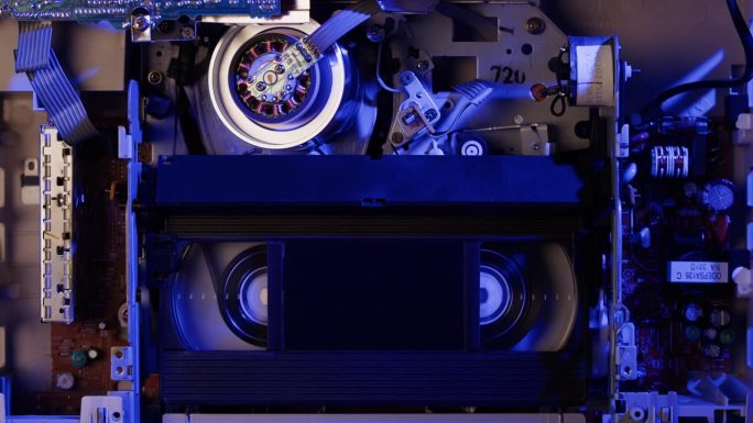 旧录像机里面的特写，VHS。复古播放器在霓虹蓝光，老式录像带广播，录音带。