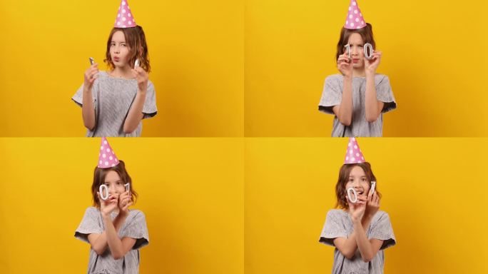 快乐，积极的十岁生日女孩戴着派对帽，点着蜡烛