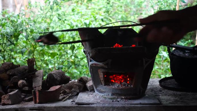 用一个不锈钢锅和一个英国炭炉，以一种质朴、复古的方式准备食物。长时间形成的深煤烟色木炭炉亮起红灯。柴