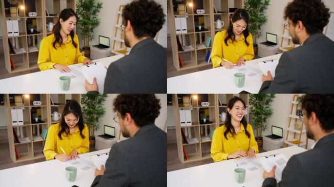 一名日本女子在与一名男性房地产经纪人会面时正在签署合同