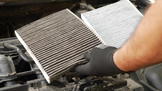 用新的空气过滤器替换旧的堵塞的空气过滤器。汽车修理和保养。