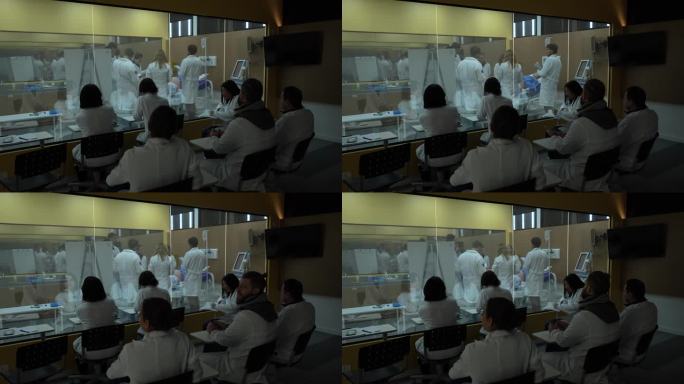 医学生透过玻璃窗在教室外观察实习课程